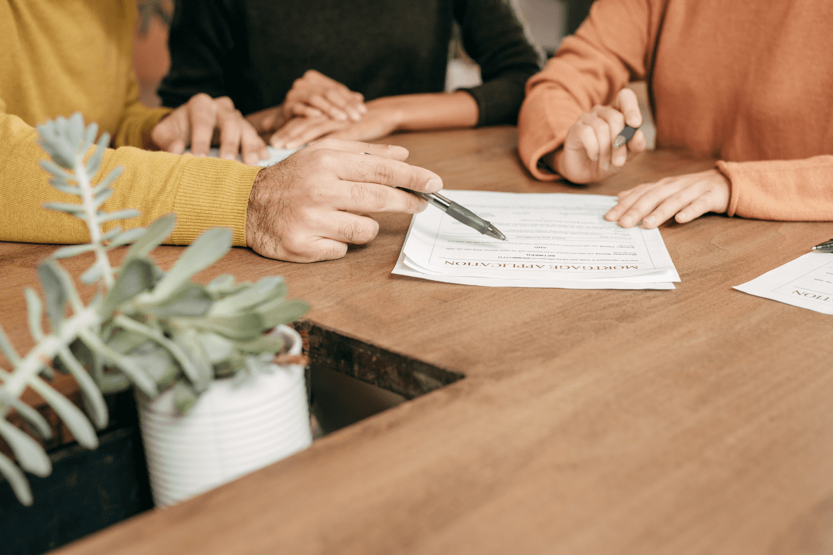 Pareja firmando la escritura de una hipoteca con condiciones favorables para la compra de su vivienda